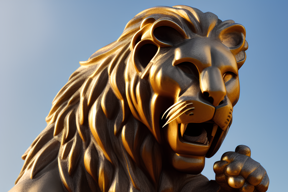 A low angle photo of a statue against a sky full of blue. The statue is of a lion with it's mouth open and it's teeth showing.